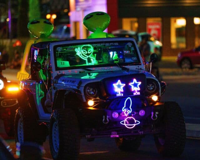 Jeep décorée d'extraterrestres gonflables et de néons lors d'une parade nocturne du UFO Festival